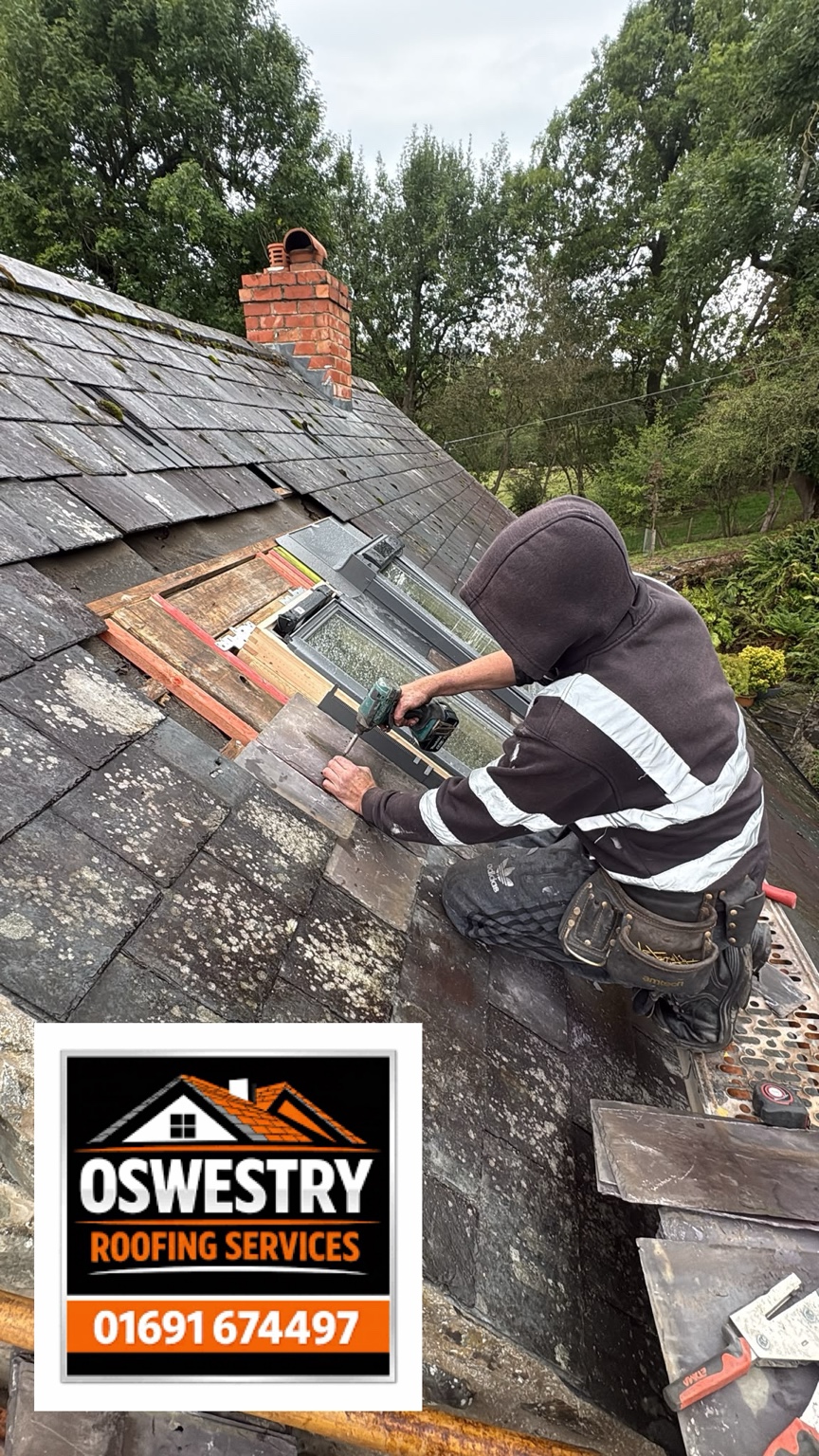 Roofer carrying out repairs to a slate roof
