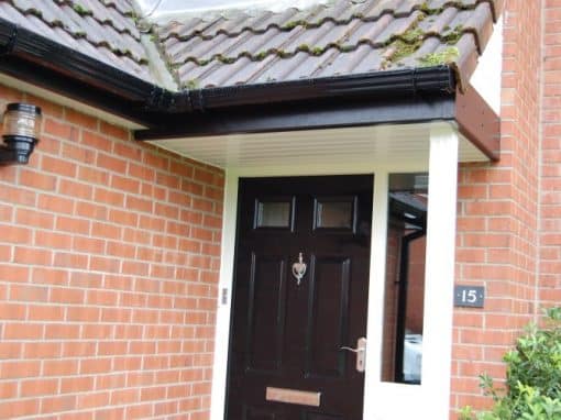 Oswestry Roofing Services Black guttering, white soffits and fascia boards fitted around a tiled entrance canopy for roofing work in Oswestry